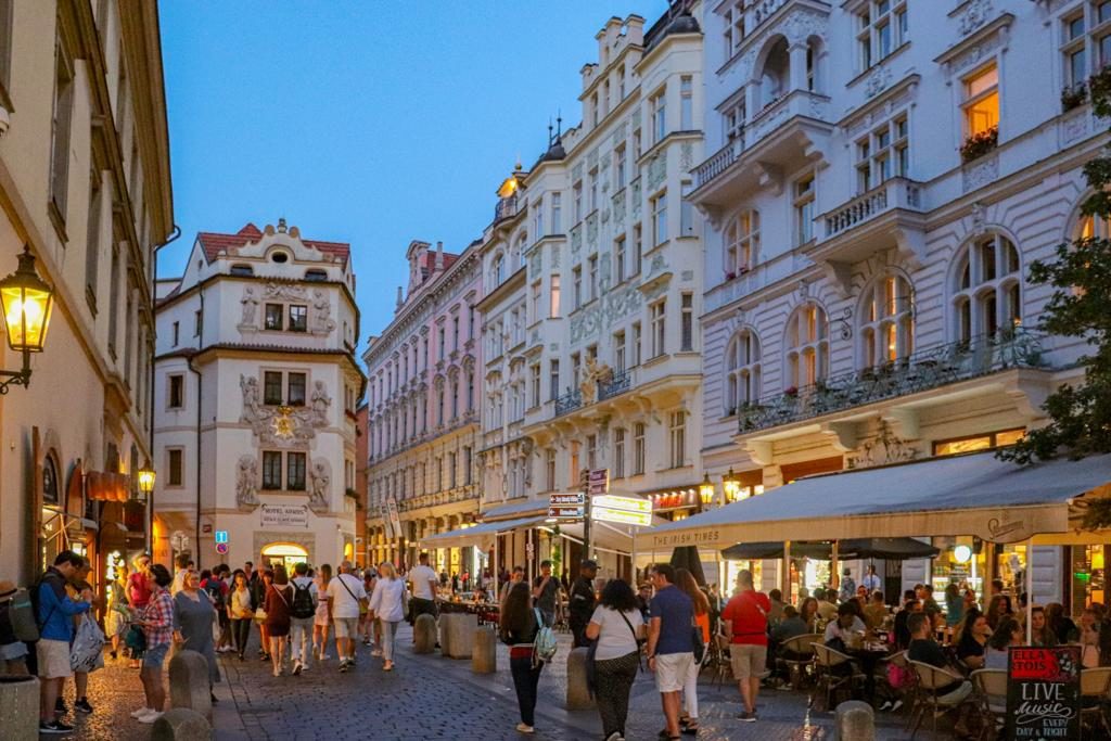 Pessoas caminhando em rua do centro histórico de Praga